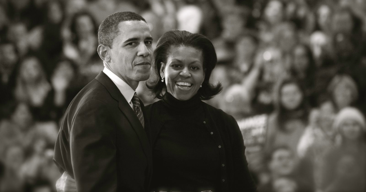 Monochrome image of Barack and Michelle Obama exiting the stage after a campaign stop in Des Moines, IA.